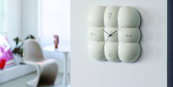 Modern wall clock with geometric design on a white wall